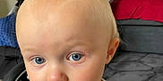 Leo joined the competition — help win amazing prizes! toddler, child, baby, face, blue_eyes, blond_hair, indoor, couch, stroller, carpet, curious, portrait, clothing, expression, person, young_child, head, sitting, home, casual