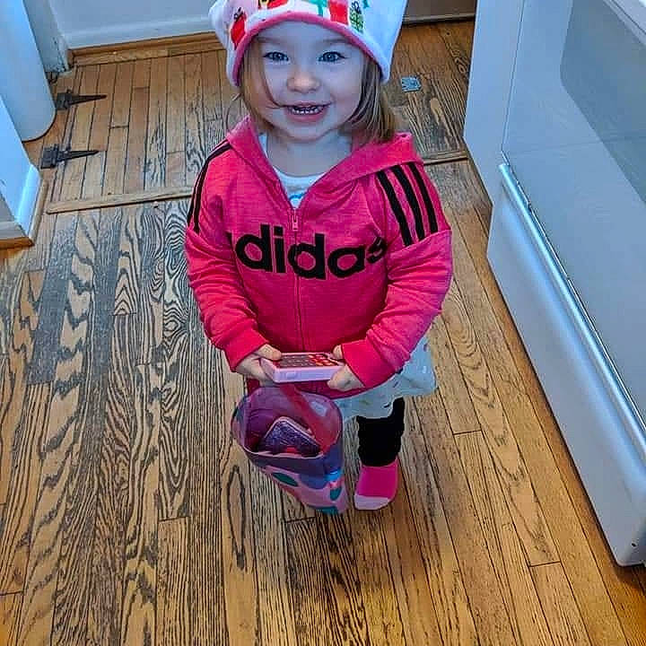Alexis is registered to the contest to win money with this photo: baby, beanie, cap, child, clothing, cool, electric_blue, floor, flooring, happy, hardwood, headgear, headwear, hood, joy, outerwear, person, pink, play, sleeve