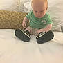 Maverick joined the competition — help win amazing prizes! baby, bed, casual_clothing, child, curious, fabric, footwear, green_shirt, headboard, home_interior, indoors, infant, person, pillow, portrait, sitting, sneakers, soft_lighting, white_bed, young_child