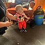Maverick joined the competition — help win amazing prizes! toddler, child, mickey_mouse_shirt, orange_pants, carpet, armchair, dog, adult_hand, vacuum_cleaner, backpack, shoes, window, curtains, wood_paneling, indoor, person, standing, support, home, lighting