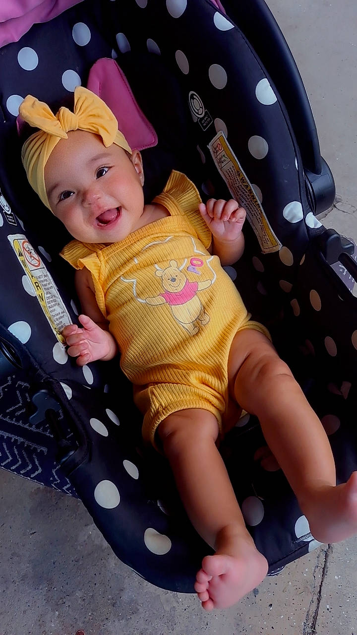 Aaliyah joined the competition — help win amazing prizes! baby, baby_toddler_clothing, chair, cheek, comfort, fun, happy, headwear, human_leg, knee, lap, organ, pattern, person, pink, product, skin, sleeve, smile, sock