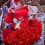 baby, child, red_bow, red_dress, tutu, blanket, winnie_the_pooh, toddler, cute, festive, holiday, headband, indoor, clothing, infant, person, smile, lying_down, soft_toys, floor