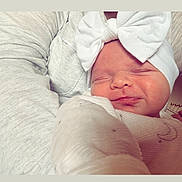 Thaïs participe au concours pour gagner de l'argent avec cette photo : baby, infant, sleeping, headband, bow, blanket, person, closeup, face, newborn, soft, cozy, cute, resting, indoor, warm, smiling, child, portrait, tender