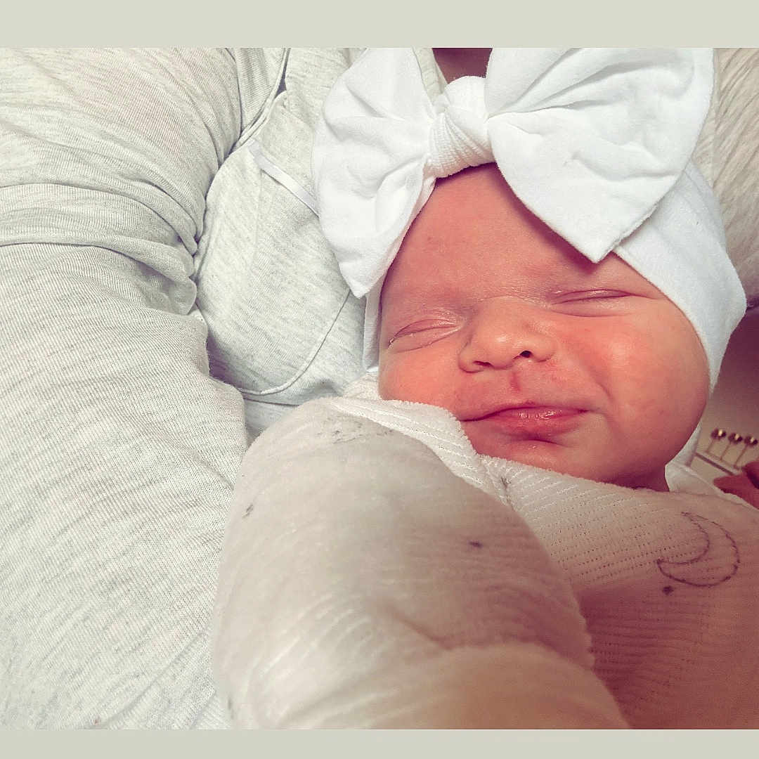 Thaïs participe au concours pour gagner de l'argent avec cette photo : baby, blanket, bow, child, closeup, cozy, cute, face, headband, indoor, infant, newborn, person, portrait, resting, sleeping, smiling, soft, tender, warm