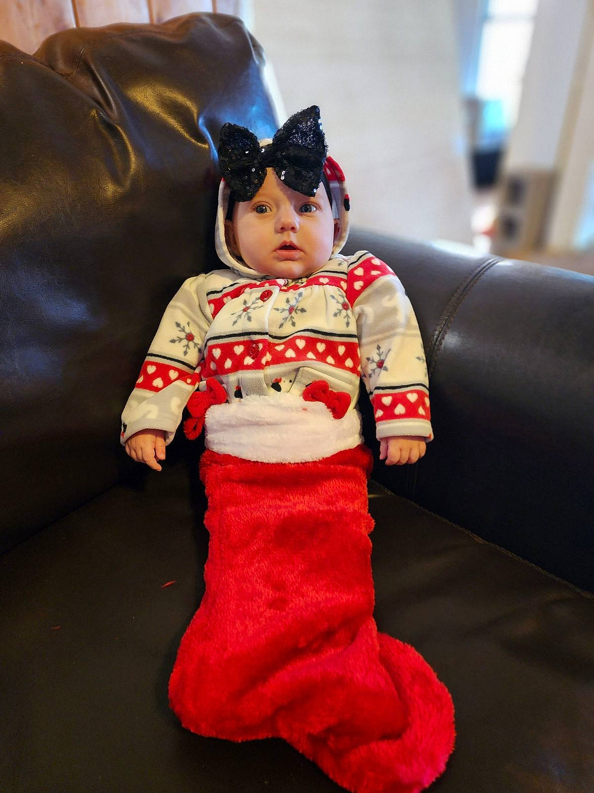 Ivy is registered to the contest to win money with this photo: baby_toddler_clothing, cap, carmine, child, christmas, comfort, costume, couch, fashion_design, flooring, headgear, headwear, human_body, human_leg, leg, person, personal_protective_equipment, room, sitting, sleeve