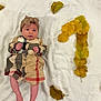 baby, infant, child, dress, headwrap, blanket, autumn_leaves, yellow_leaves, plaid_pattern, question_mark, soft_texture, lying_down, indoors, cute, small_hands, small_feet, portrait, fall, seasonal, decor