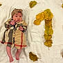 baby, infant, dress, headband, plaid, blanket, autumn_leaves, yellow_leaves, number_one, celebration, milestone, lying_down, cute, portrait, child, skin, feet, hand, indoors, fall