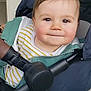 baby, child, closeup, clothing, cute, face, handlebar, happy, head, indoor, jacket, person, rosy_cheeks, seated, smile, striped_shirt, stroller, transport, wheel, young_child