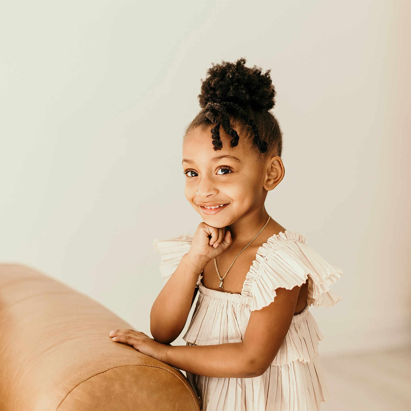 Zoey is registered to the contest to win money with this photo: accessories, blackhair, child, clothing, couch, dress, face, female, formalwear, furniture, girl, happy, head, jewelry, necklace, person, photography, portrait, sitting, smile