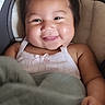 baby, smiling, blanket, car_seat, child, cute, infant, portrait, happy, face, hair, clothing, sitting, indoors, person, screen_capture, social_media, mobile_phone, digital_photo, app_interface