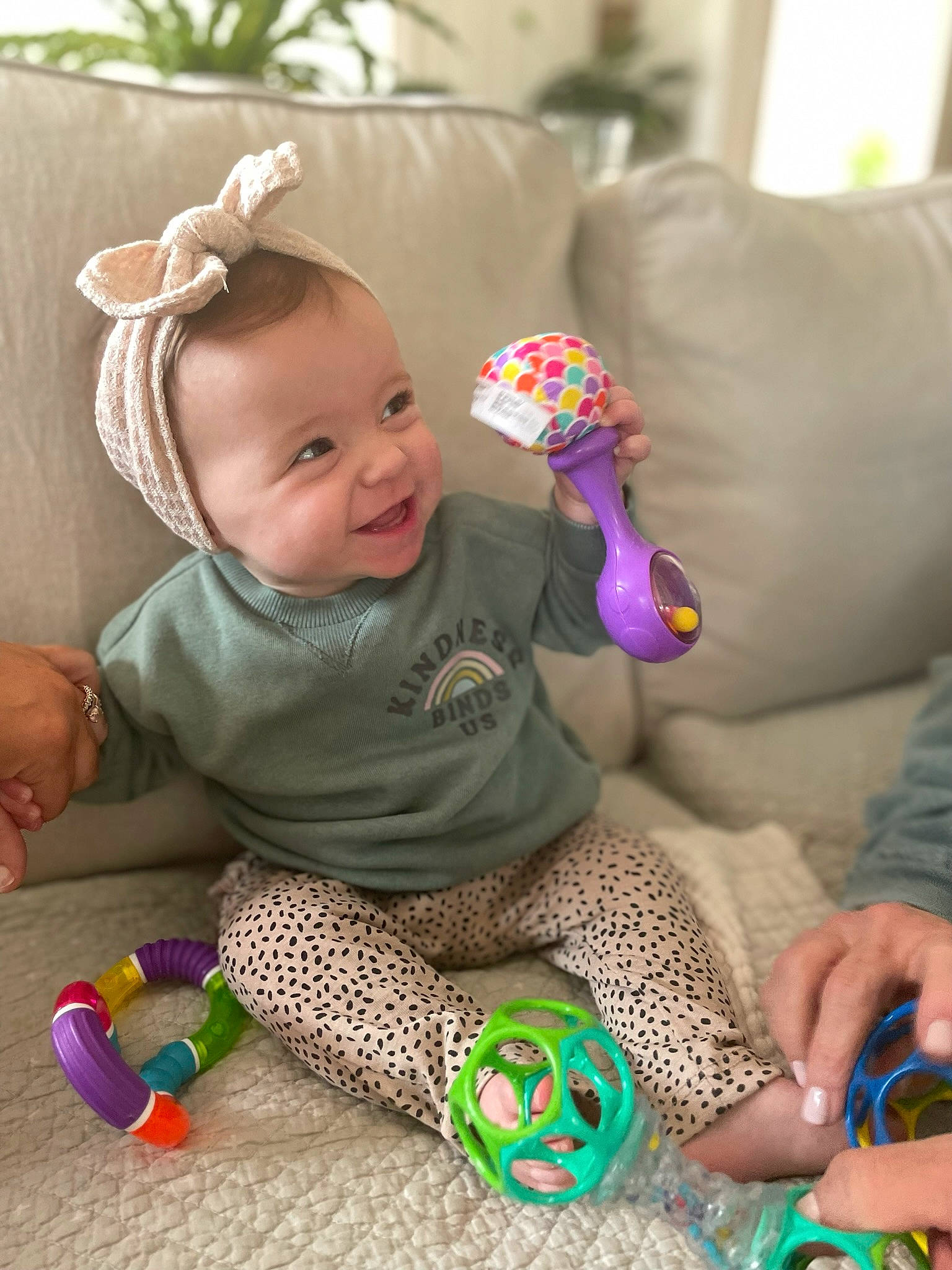 Kora joined the competition — help win amazing prizes! baby, baby_toddler_clothing, child, comfort, couch, finger, fun, grass, happy, nail, pattern, person, room, sitting, skin, smile, sock, textile, toddler, toy