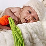 baby, infant, knitted_hat, bunny_ears, carrot_toy, blanket, soft_texture, cute, smiling, portrait, close_up, sleepy, hand, foot, cozy, warm, child, newborn, resting, indoor