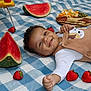 baby, smiling, picnic, blanket, strawberry, watermelon, cheese, crackers, food, fruit, plate, child, happy, outdoor, cute, person, clothing, toddler, tableware, relaxing