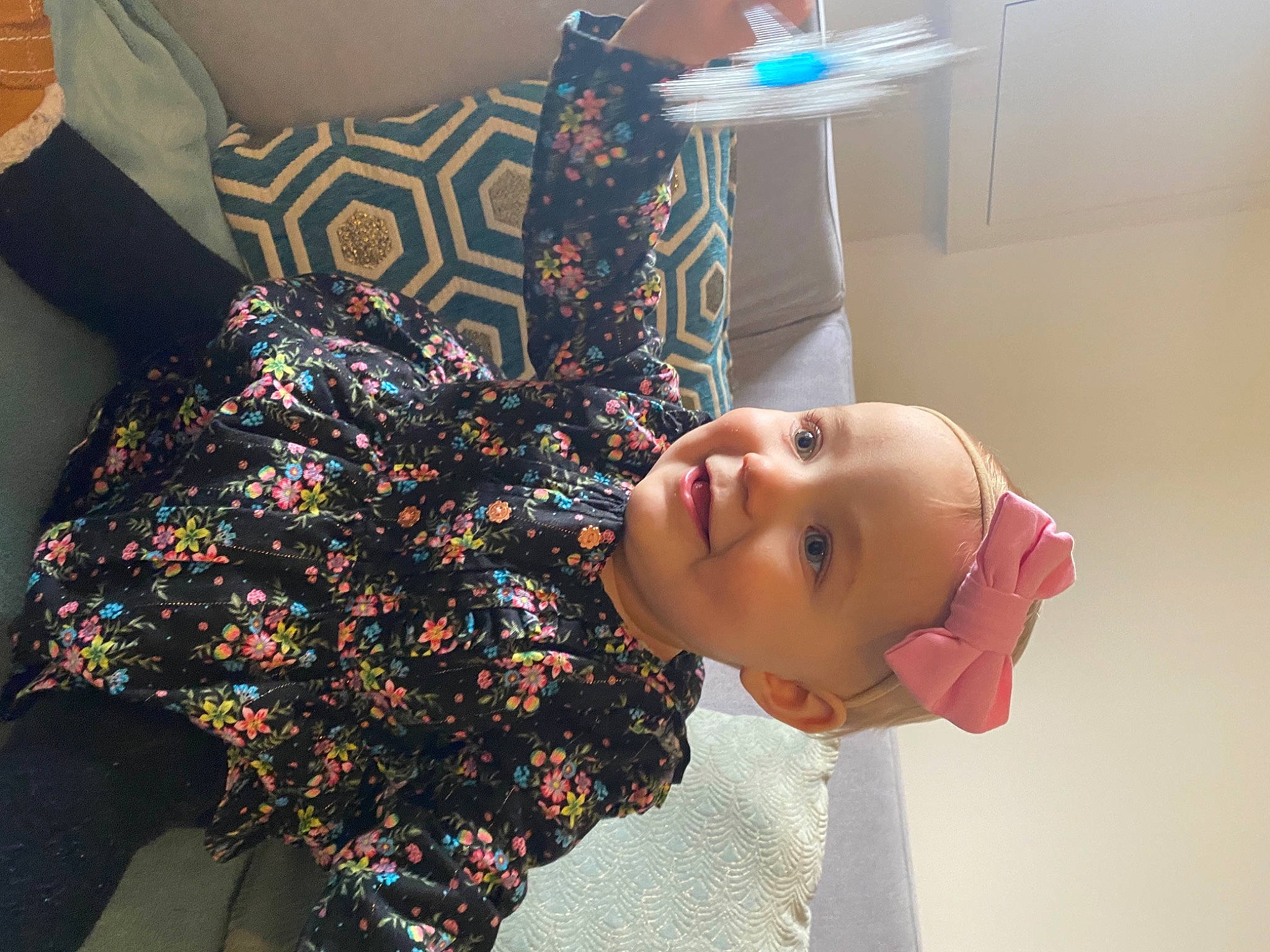 Clara participe au concours pour gagner de l'argent avec cette photo : baby, baby_toddler_clothing, carmine, child, couch, flooring, fun, happy, joy, linens, magenta, pattern, person, pillow, play, room, shoulder, sleeve, smile, textile