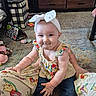 Kimi joined the competition — help win amazing prizes! baby, child, headband, bow, floral_clothing, sitting, indoor, carpet, toy, furniture, person, smile, funny_face, home, lap, jeans, cute, plush_toy, living_room, expression