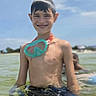 child, smiling, water, snorkel_mask, summer, beach, sky, outdoor, swimming, boy, happy, sunny, recreation, vacation, nature, fun, person, shore, holiday, playful