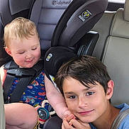 David is registered to the contest to win money with this photo: child, car_seat, car_interior, seatbelt, toddler, boy, smile, sibling, sitting, window, clothing, short_hair, car, family, seat, safety, cute, happy, travel, bonding