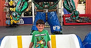 David joined the competition — help win amazing prizes! child, boy, smiling, sitting, bench, robot_statue, green_tshirt, minecraft, blue_shorts, outdoor, storefront, sign, advertisement, toy, happy, portrait, daylight, casual_clothing, urban, public_place