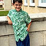 David joined the competition — help win amazing prizes! child, boy, smile, green_shirt, minecraft, casual_pose, stone_wall, brick_building, windows, outdoor, daylight, short_hair, happy, standing, clothing, person, portrait, urban, young, fashion