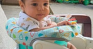 Elijah is registered to the contest to win money with this photo: baby, child, infant, highchair, seat, outdoor, garden, plants, toy, curious, cute, person, face, portrait, colorful, clothing, table, sun_emoji, name_overlay, casual
