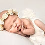 newborn, baby, sleeping, flower_crown, white_blanket, infant, peaceful, soft_texture, closeup, portrait, cute, tiny_hands, tiny_feet, skin, headband, resting, cozy, innocence, studio, white_background