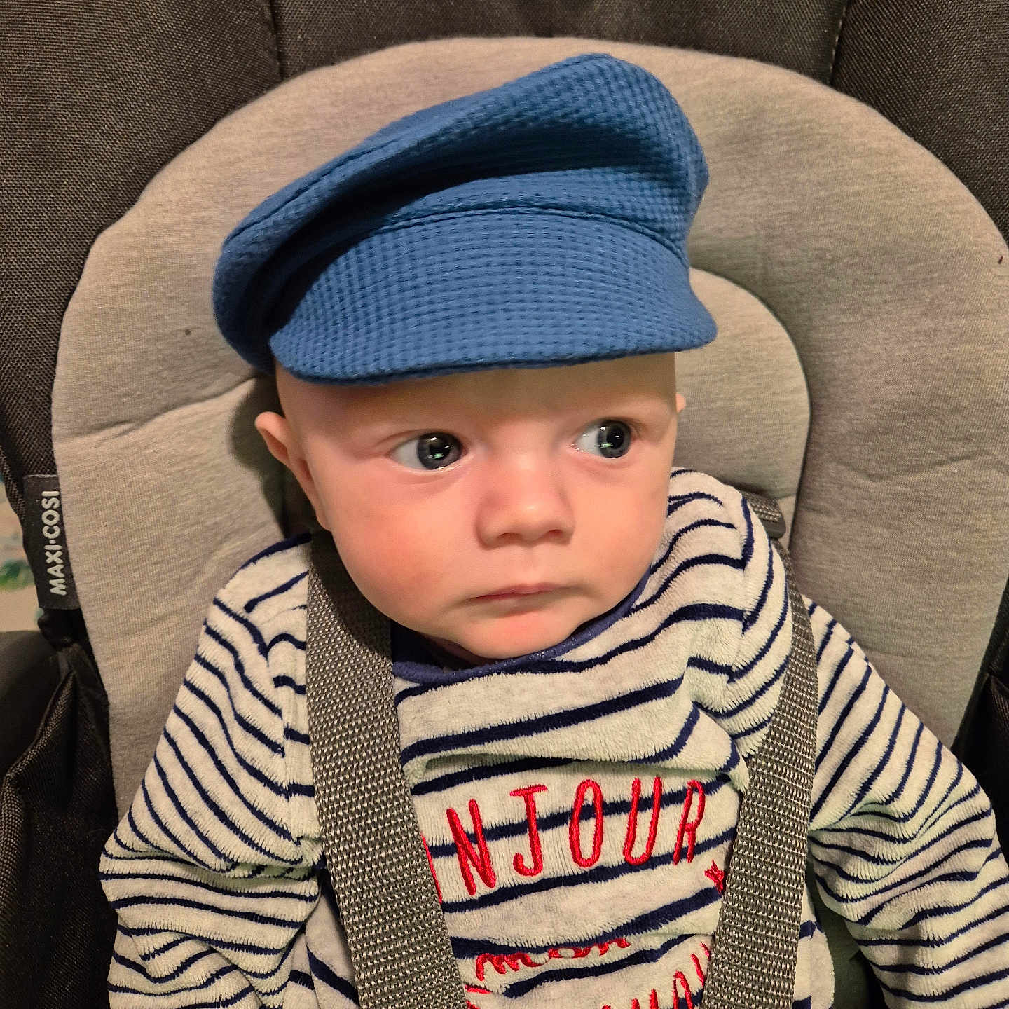 Alec-Nikita participe au concours pour gagner de l'argent avec cette photo : apparel, baby, blue_cap, car_seat, child, clothing, cute, expression, face, headwear, indoor, infant, maxi_cosi, person, portrait, seatbelt, sitting, straps, striped_sweater, young_child