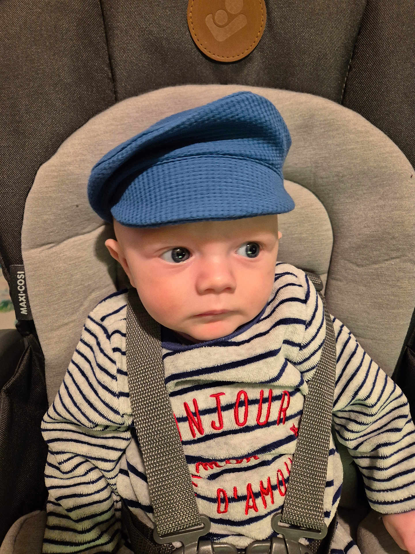 Alec-Nikita participe au concours pour gagner de l'argent avec cette photo : apparel, baby, blue_cap, car_seat, child, clothing, cute, expression, face, headwear, indoor, infant, maxi_cosi, person, portrait, seatbelt, sitting, straps, striped_sweater, young_child