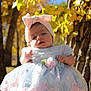 Hazel joined the competition — help win amazing prizes! baby, child, infant, dress, headband, bow, flower, outdoor, nature, tree, yellow_leaves, sunlight, portrait, cute, young_child, seasonal, fall, fashion, person, head