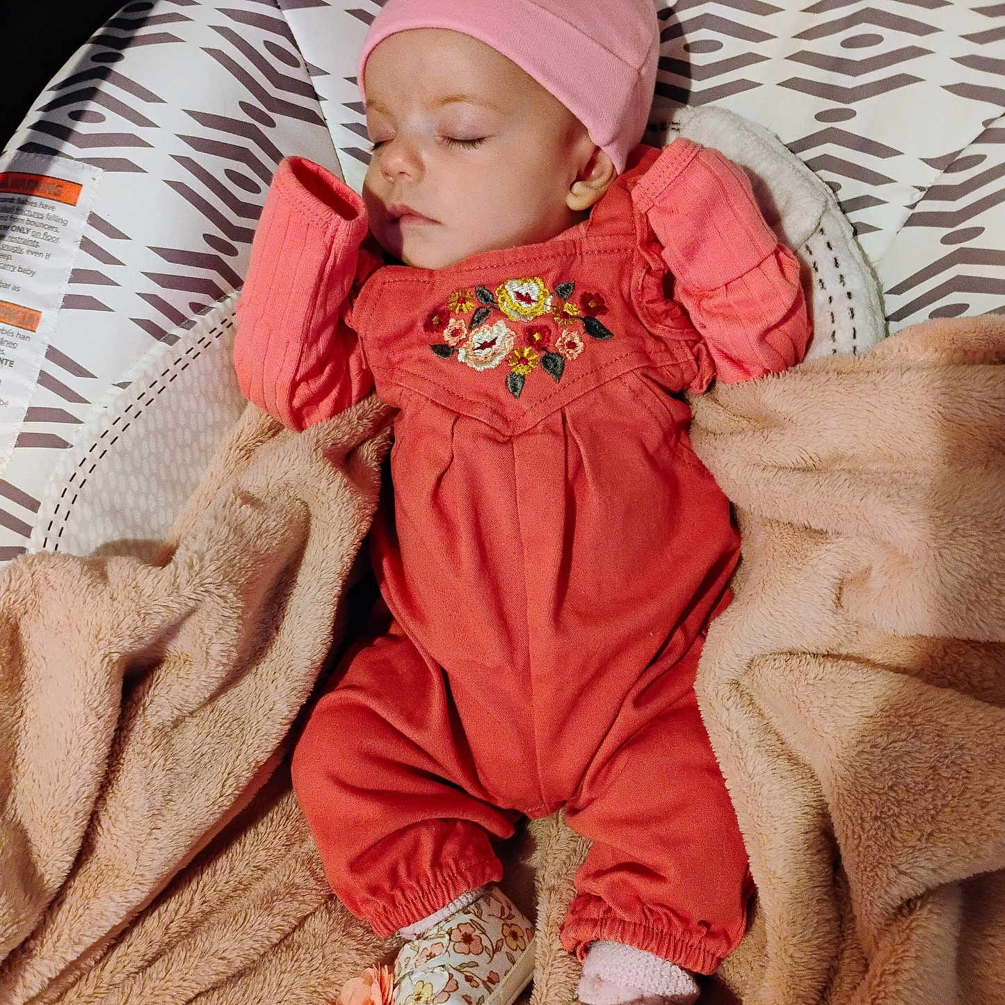 Hazel is registered to the contest to win money with this photo: baby, baby_seat, blanket, child, clothing, comfort, coral, cozy, cute, footwear, hat, indoors, infant, patterned, peaceful, pink, portrait, resting, sleeping, soft_texture