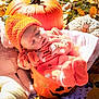 baby, infant, sleeping, orange, knitted_hat, pumpkin_bucket, halloween, autumn_leaves, fall, outdoor, cozy, blanket, seasonal, cute, child, soft_toys, nature, festive, warm_clothing, relaxation