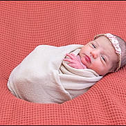 Clara participe au concours pour gagner de l'argent avec cette photo : newborn, baby, infant, wrapped, blanket, headband, pink, coral, texture, sleepy, portrait, cute, soft, peaceful, resting, young, child, face, hand, cozy