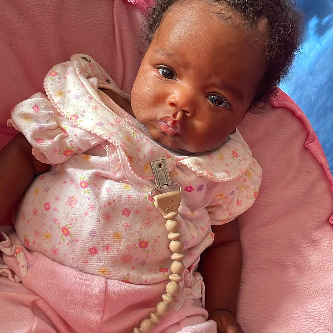 Sakyia is registered to the contest to win money with this photo: baby, bed, bodypart, bonnet, clothing, couch, crib, dress, face, finger, furniture, hand, happy, hat, head, infantbed, person, photography, portrait, smile