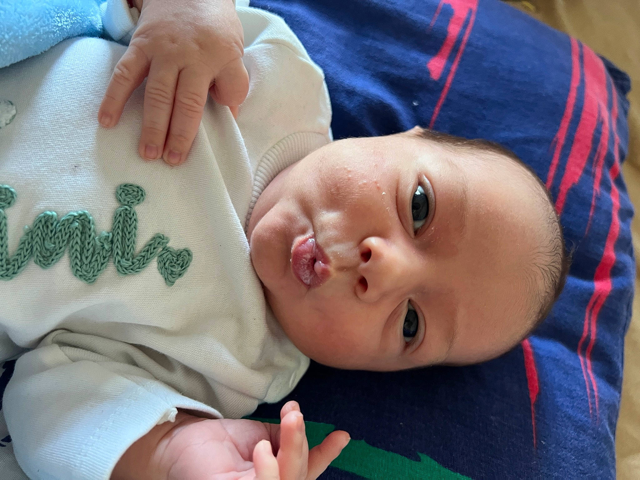 Akim participe au concours pour gagner de l'argent avec cette photo : arm, baby, baby_toddler_clothing, blue, cheek, eye, facial_expression, finger, gesture, hand, human, lip, mammal, nose, organ, person, product, skin, sleeve, textile