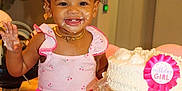 Autumn is registered to the contest to win money with this photo: child, toddler, birthday_cake, cake, pink_clothing, smiling, happy, curly_hair, face_paint, messy, celebration, party, ribbon, jewelry, necklace, earrings, table, indoor, plant, foot