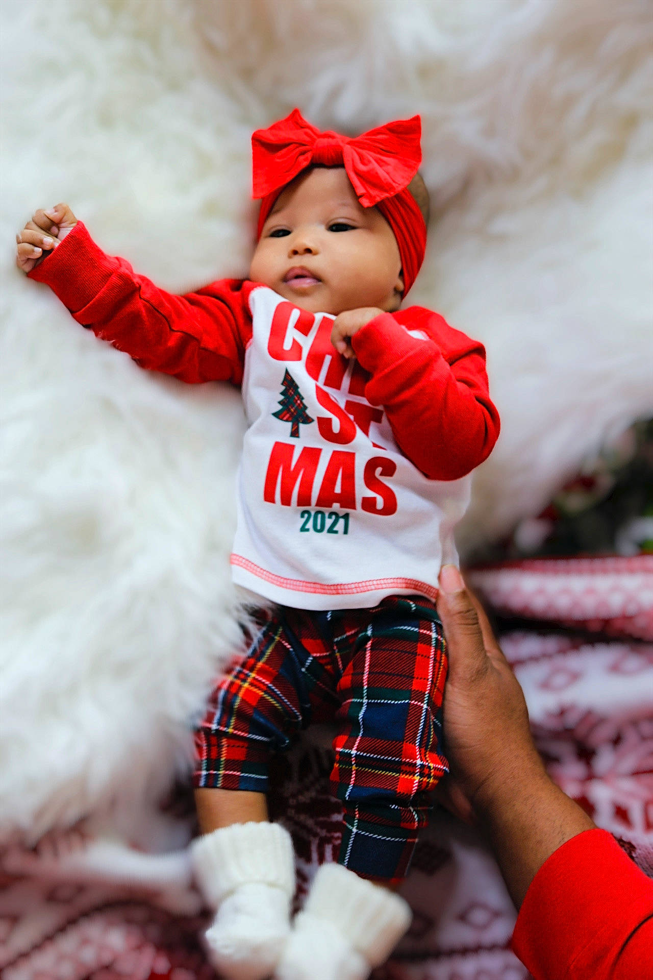 Nia joined the competition — help win amazing prizes! arm, baby, baby_toddler_clothing, christmas, event, fun, fur, happy, headwear, holiday, outerwear, pattern, person, plaid, red, sleeve, sock, sportswear, tartan, textile
