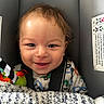 baby, infant, car_seat, smile, happy, blanket, clothing, face, child, seatbelt, closeup, cute, indoors, head, person, portrait, toy, colorful, young, baby_toy