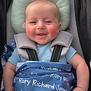 Rory is registered to the contest to win money with this photo: baby, smiling, blanket, blue_blanket, stroller, child, infant, face, head, rosy_cheeks, clothing, cushion, straps, person, happy, sitting, comfort, cute, portrait, baby_boy