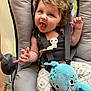 baby, child, infant, smiling, happy, curly_hair, plush_toy, octopus, seat, baby_seat, straps, clothing, patterned_pants, cute, playful, indoor, portrait, person, young_child, expression
