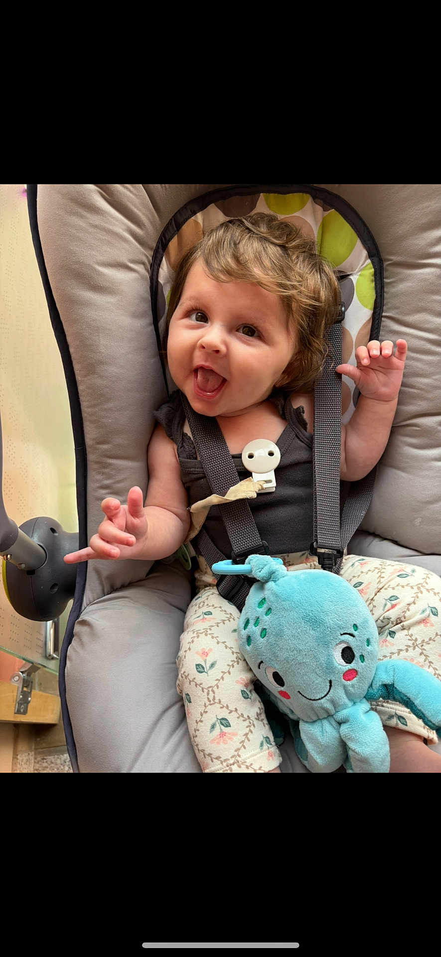 Eléana a rejoint le concours — aidez-le/la à gagner de superbes lots ! baby, child, infant, smiling, happy, curly_hair, plush_toy, octopus, seat, baby_seat, straps, clothing, patterned_pants, cute, playful, indoor, portrait, person, young_child, expression