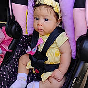 Trinity is registered to the contest to win money with this photo: baby, car_seat, child, child_fashion, closeup, cute, harness, headband, indoors, infant, person, portrait, purple_cushion, safety, seatbelt, serious_expression, sitting, skin, socks, yellow_clothing