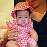 Trinity is registered to the contest to win money with this photo: adult, baby, candid, casual, checkered_pattern, child, cute, expression, face, family, hand, hat, holding, indoor, people, person, pink_clothing, portrait, sitting, skin