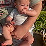 Emmett Sherwood is registered to the contest to win money with this photo: baby, child, person, adult, arm, hand, outdoor, sunlight, greenery, plants, flower, casual_clothing, shorts, tshirt, legs, skin, sitting, holding, face, expression