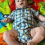 baby, carpet, casual, child, colorful, cute, expression, fabric, face, hands, indoor, infant, legs, lying_down, pattern, person, plaid_clothing, play_mat, romper, soft