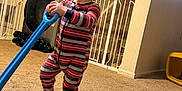 Dominic is registered to the contest to win money with this photo: appliance, baby_gate, blue_toy, carpet, child, child_playing, face, floor, furniture, handrail, home_interior, indoor, laundry_machines, person, smiling, staircase, striped_pajamas, toddler, toy, yellow_toy_container