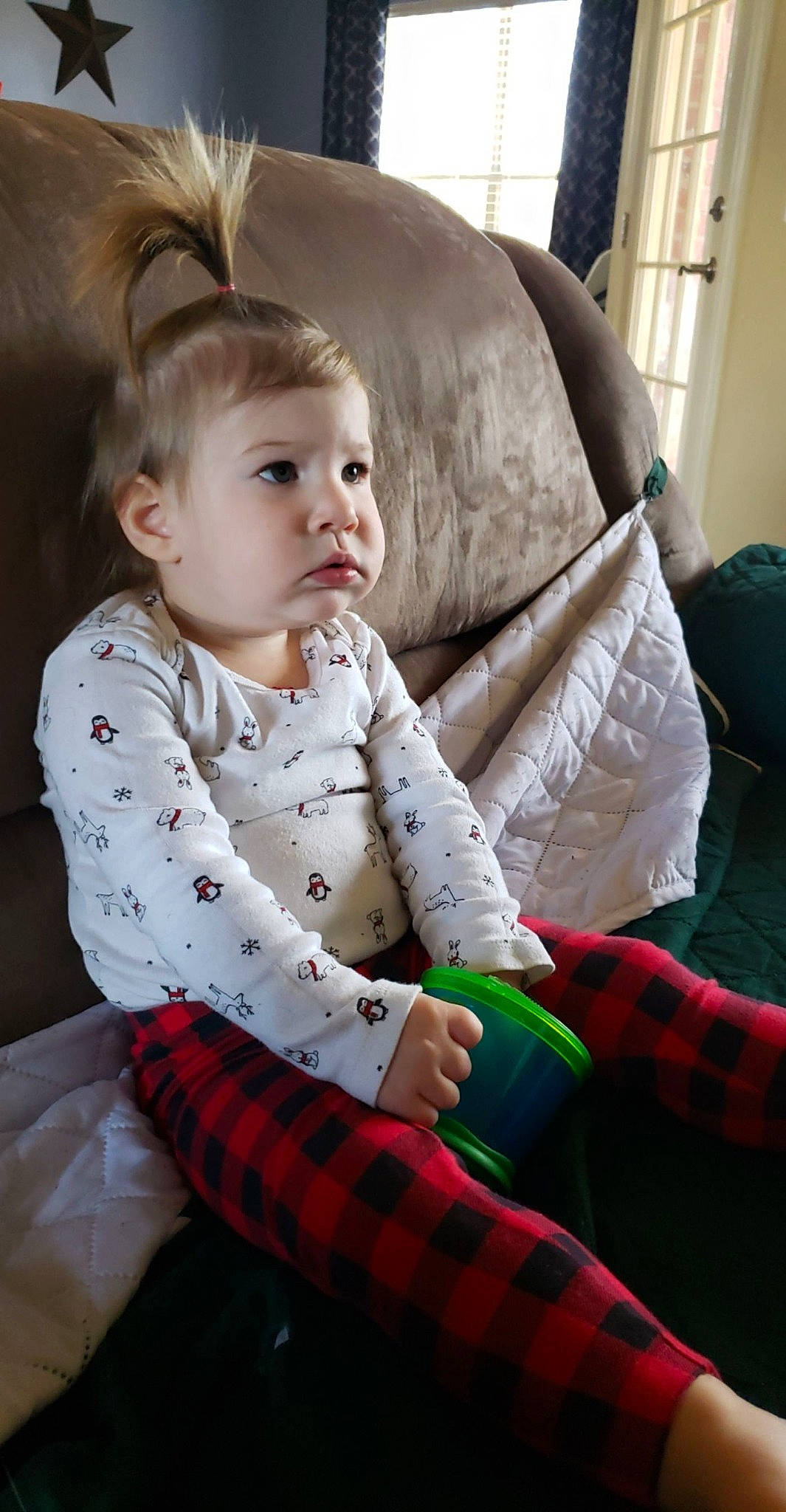 Elsa is registered to the contest to win money with this photo: baby, baby_toddler_clothing, child, child_model, comfort, design, ear, eye, hair_accessory, headband, lap, living_room, pajamas, pattern, person, plaid, sitting, sock, tartan, textile