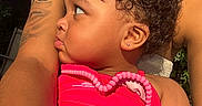 Zahmiyah Frison is registered to the contest to win money with this photo: toddler, child, curly_hair, earring, pink_outfit, strawberry_pattern, tattoo, adult_arm, sunlight, close_up, profile, outdoor, umbrella, protective, embrace, skin, person, summer, warm_light, love