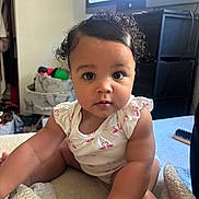 Zahmiyah Frison is registered to the contest to win money with this photo: baby, child, curly_hair, onesie, pink, flamingo, indoor, blanket, soft, face, big_eyes, sitting, room, television, storage, furniture, casual, cute, infant, portrait