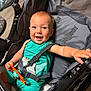 Jake joined the competition — help win amazing prizes! baby, infant, smiling, stroller, stroller_seat, harness, buckle, teething_toy, green_outfit, blue_eyes, happy, arm, hand, mesh, fabric, wheel, wood_floor, indoor, portrait, close_up