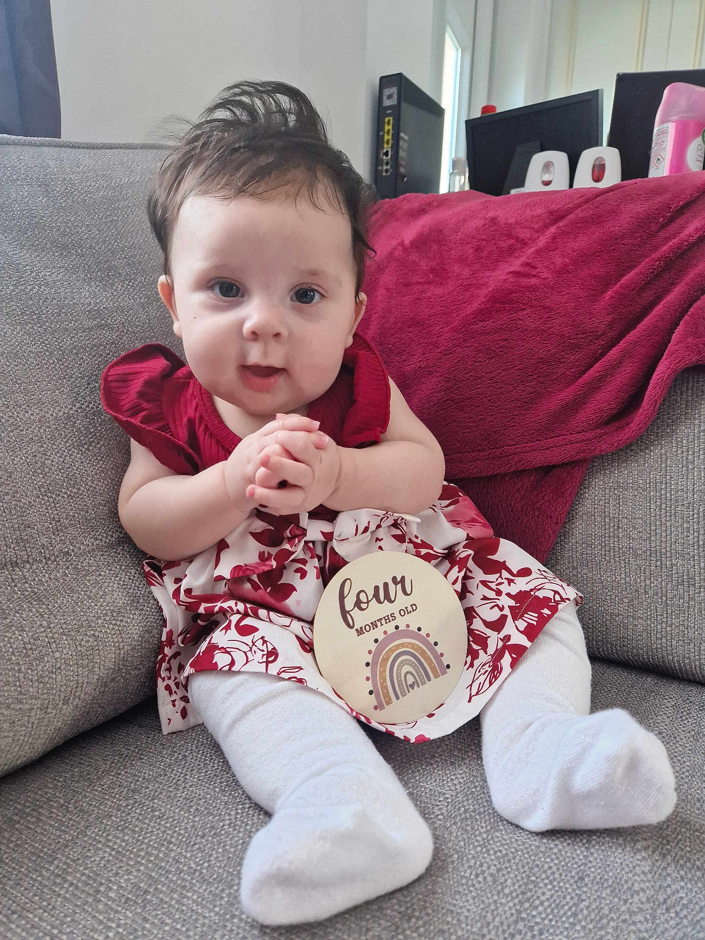 Jovi-May joined the competition — help win amazing prizes! baby, infant, child, sitting, couch, blanket, dress, white_socks, sign, four_months_old, rainbow, indoors, portrait, cute, hands_clasped, hair, face, expression, person, home