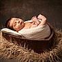 newborn, baby, sleeping, blanket, wooden_bowl, heart_shaped, fluffy_rug, cozy, portrait, infant, cute, peaceful, wrapped, soft_lighting, indoors, head, foot, skin, resting, toddler